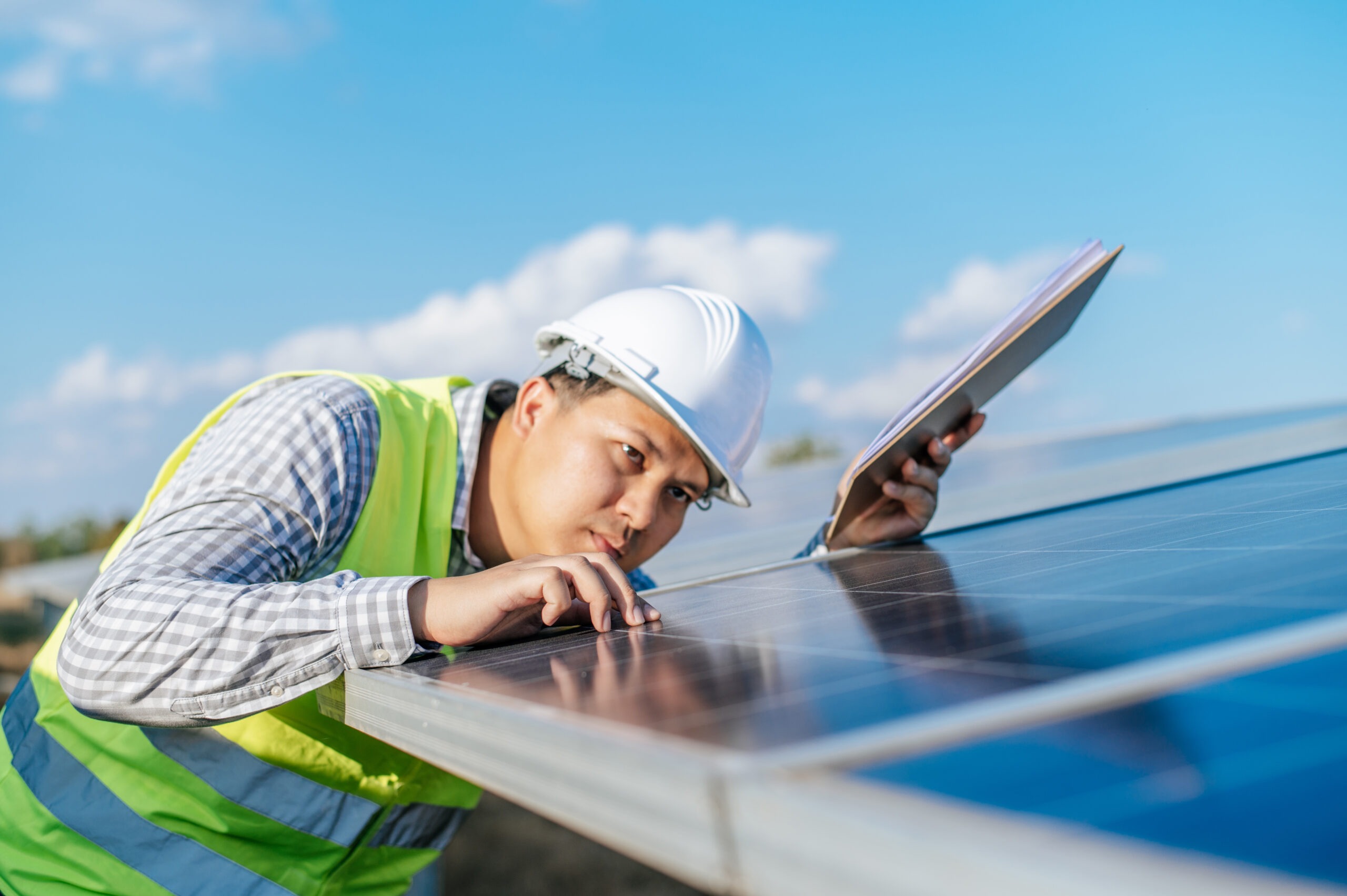 young asian inspector engineer man working solar farm technician supervisor male white helmet checking operation sun photovoltaic solar panel station copy space scaled.jpg